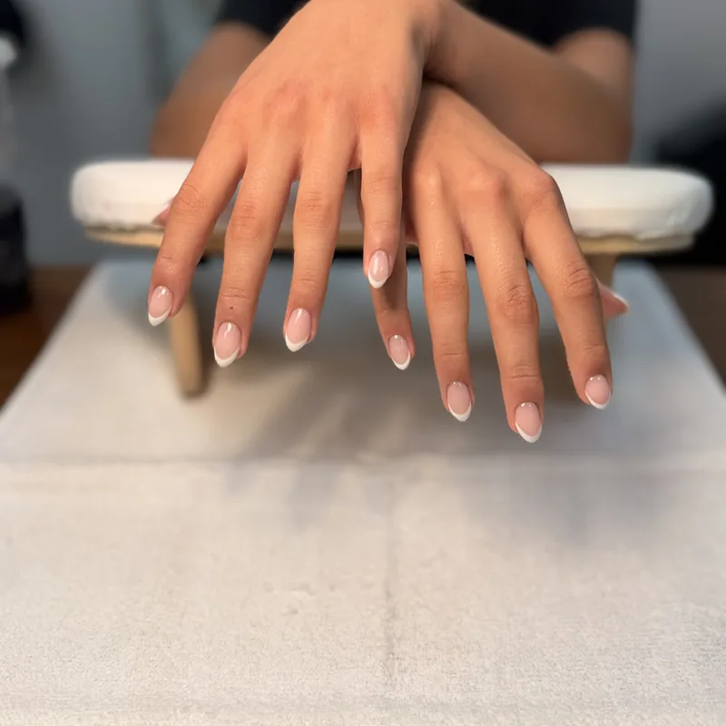 Short round nails with a classic sheer white French tip.