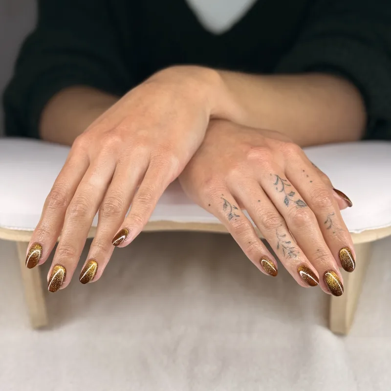Copper and bronze almond nails finished with a chrome shimmer.
