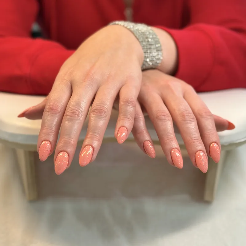 Medium-length almond nails in a warm coral.