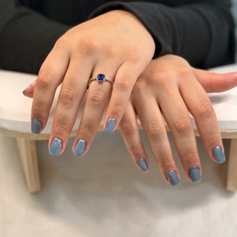 Almond nails in a dusty denim blue with a lighter accent nail.